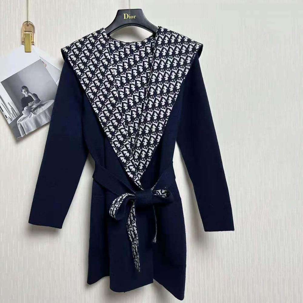 Close-up on signature Dior belt hardware on navy blue cropped wool coat