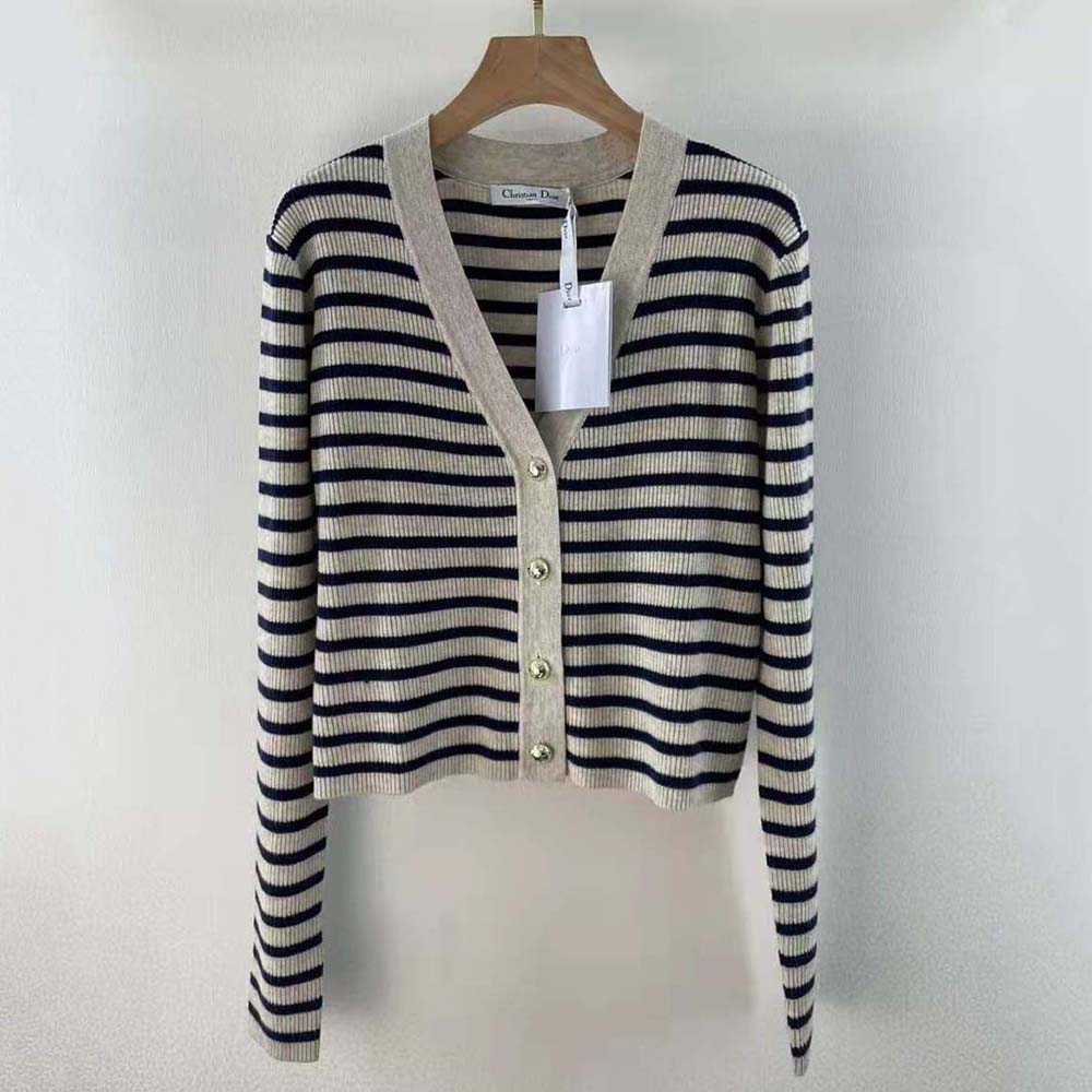 Close-up of signature Dior buttons on navy blue cardigan