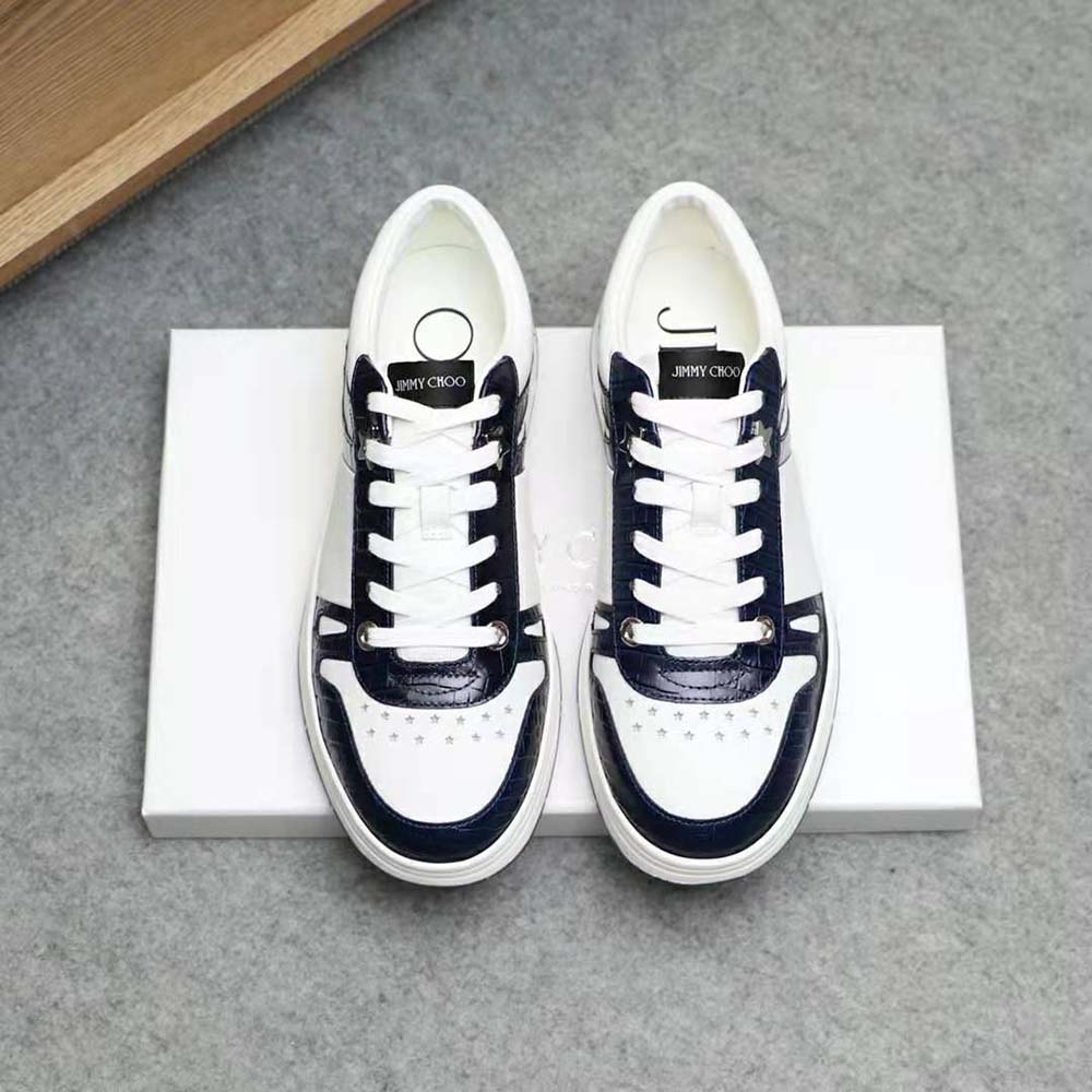 Close-up on croc-embossed blue leather detail with white calf leather panel