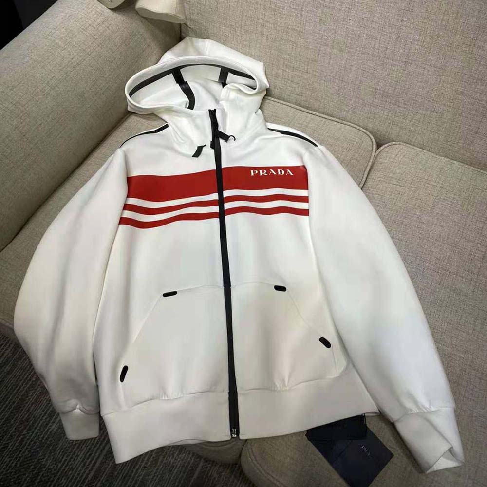 Close-up of printed technical fabric and Prada hardware on white jacket