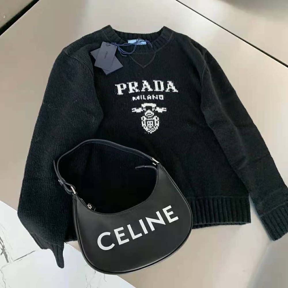Close-up of black cashmere blend fabric and Prada logo detail on sweater
