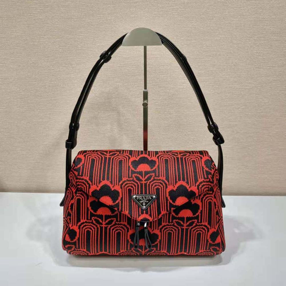 Close-up of gold Prada Signaux hardware on red jacquard knit bag
