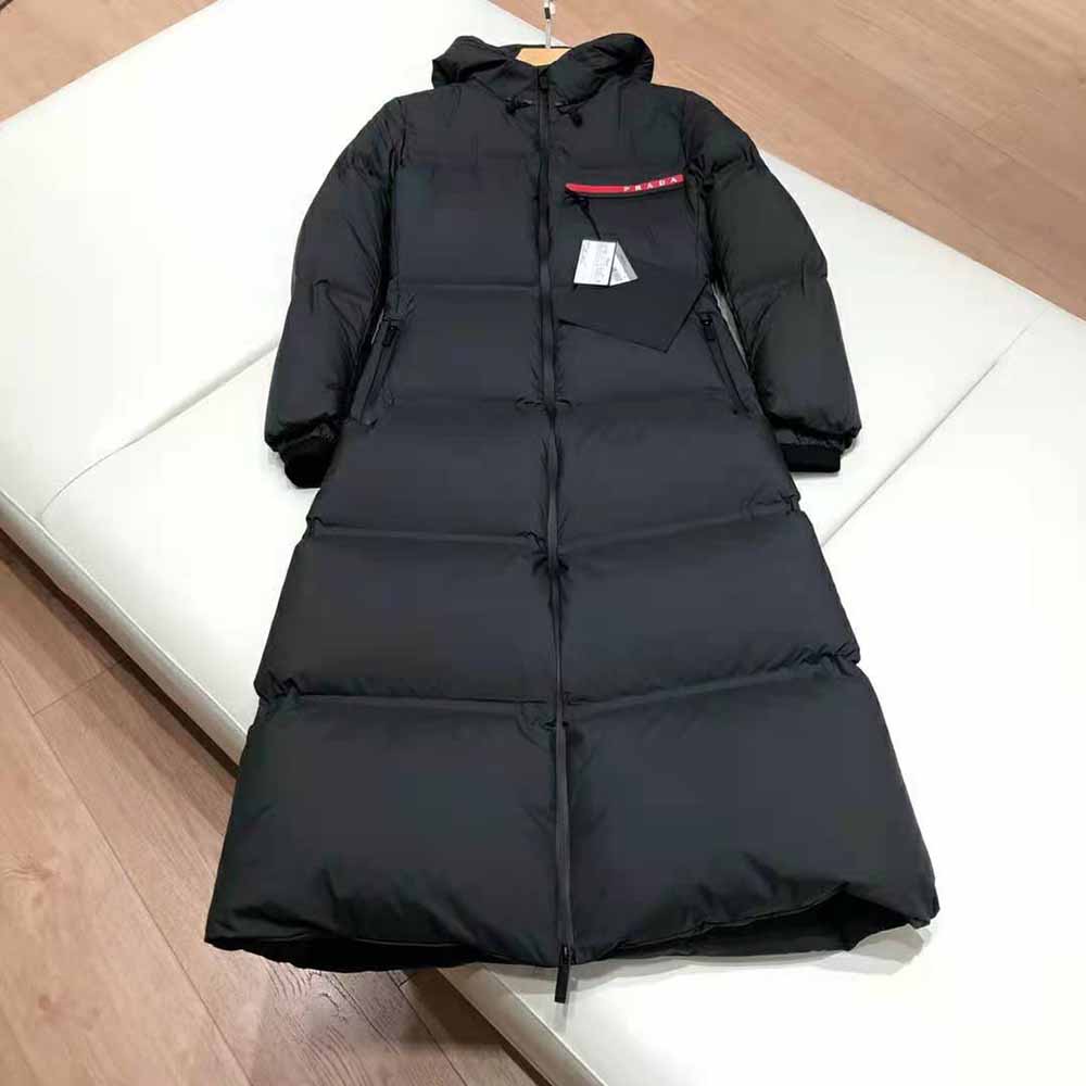 Close-up detail of Prada branded zipper on the hooded puffer coat