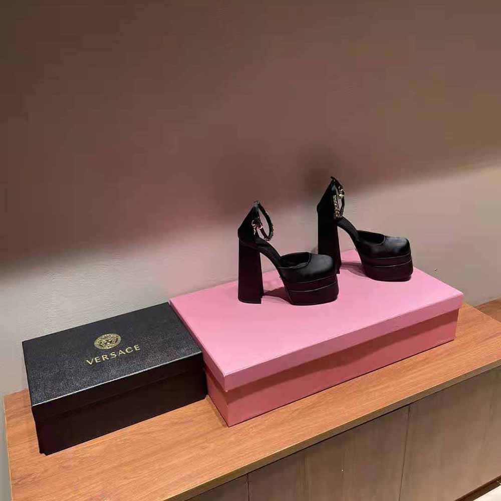 Close-up of gold Medusa hardware on Versace Women Medusa Aevitas Platform Pumps-Black