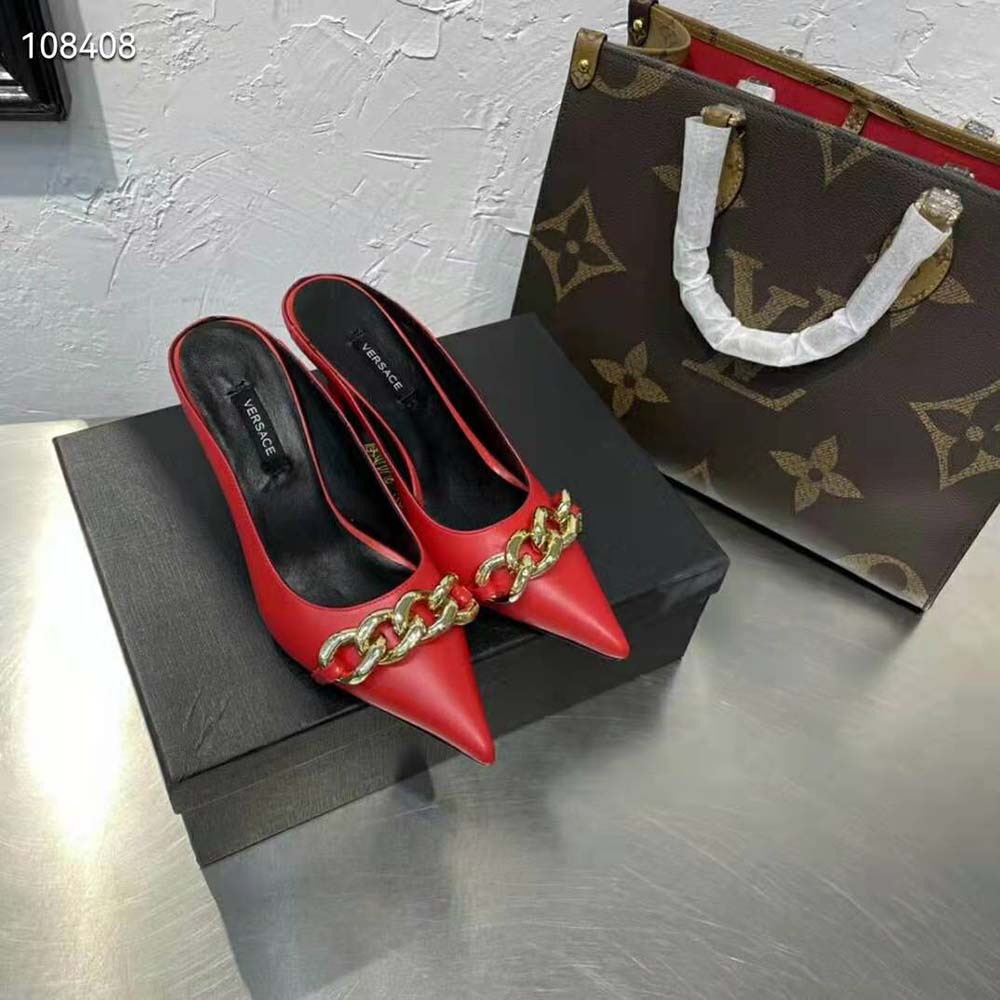 Close-up on gold Medusa chain detail of Versace red mules