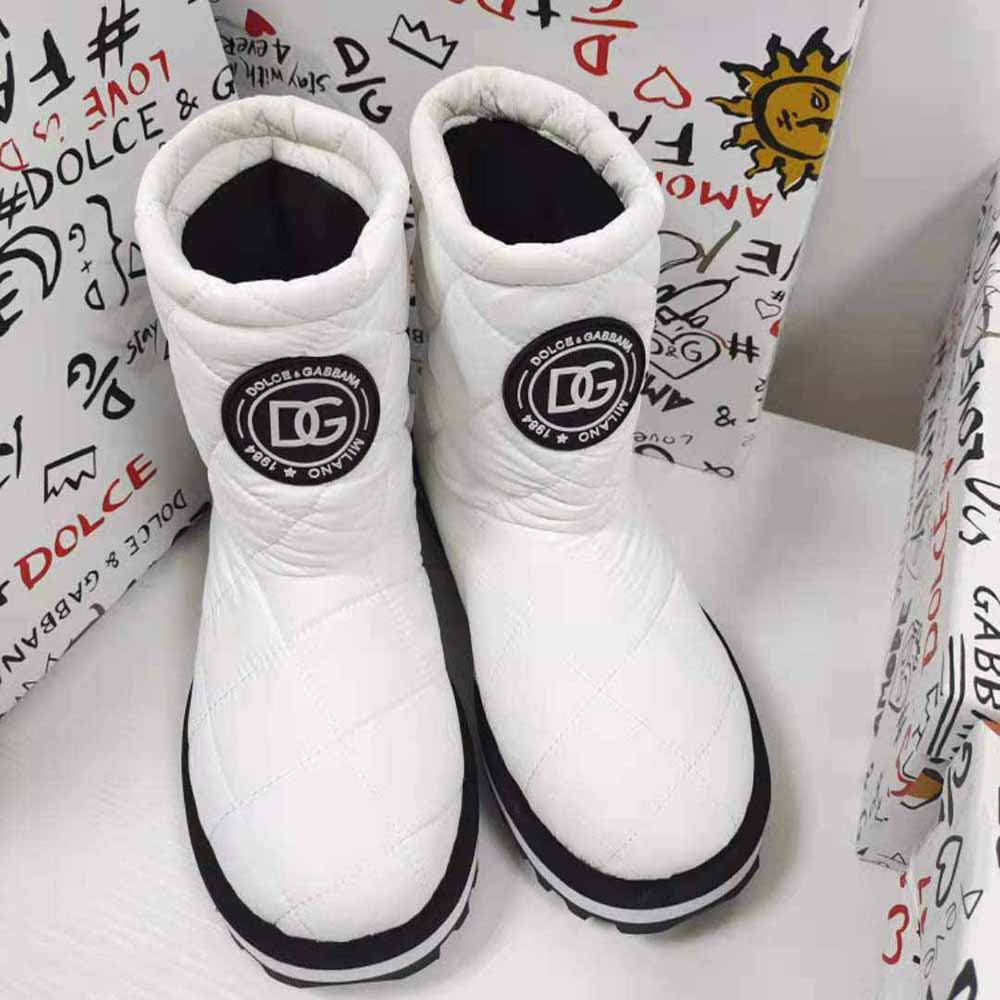 Close-up on DG logo hardware on white nylon ankle boot