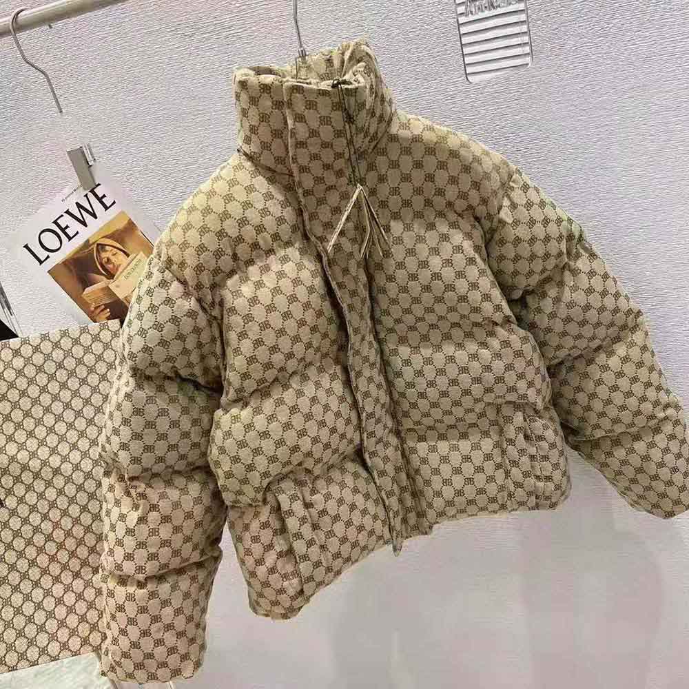 Close-up of signature BB hardware on beige and brown canvas jacquard puffer
