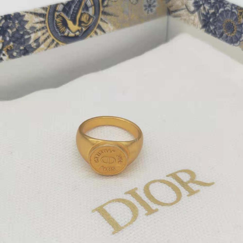 Close-up detail of Dior engraving on gold-finish ring