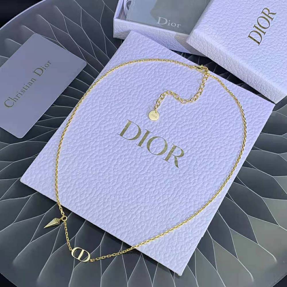 Close-up detail of gold-finish metal and CD charm on necklace