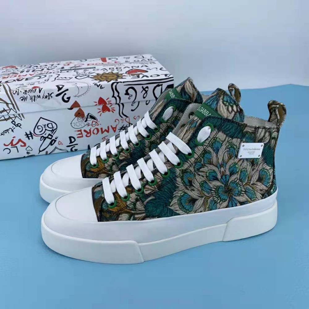 Close-up on gold-tone logo plate detail of Dolce Gabbana D&G high-top sneakers