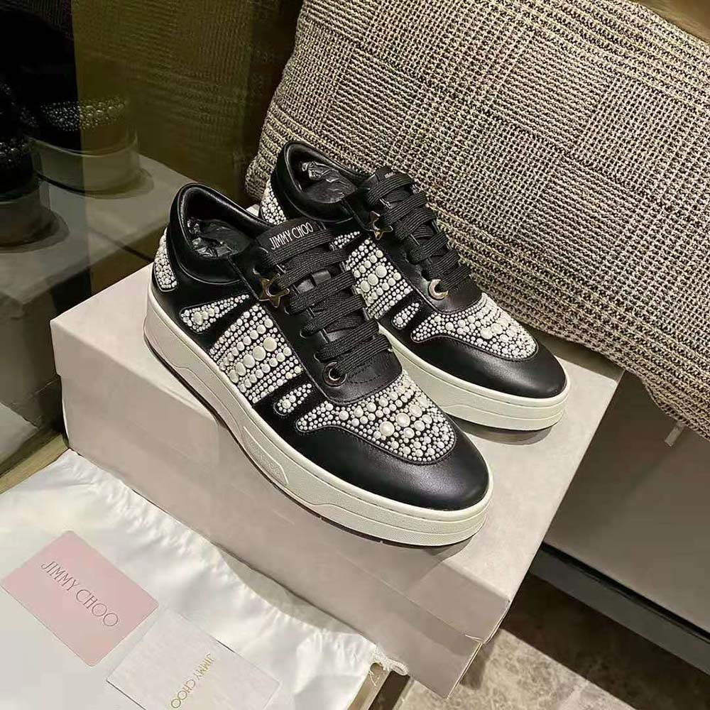 Overhead shot showing black leather and canvas textures on Jimmy Choo trainers