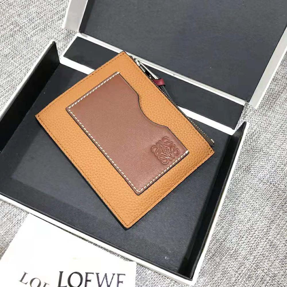 Close-up of embossed Loewe logo on brown leather cardholder