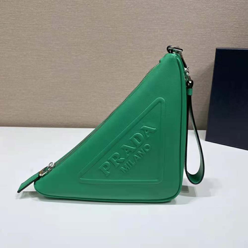 Close-up on green leather texture and silver triangle hardware of Prada pouch