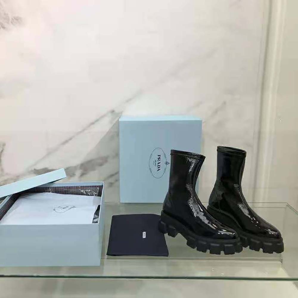 Close-up on the glossy patent leather and pointed toe detail of Prada booties