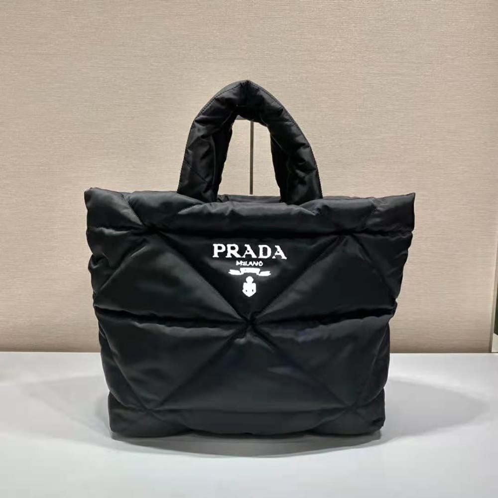 Close-up detail of Prada logo and silver hardware on padded tote bag