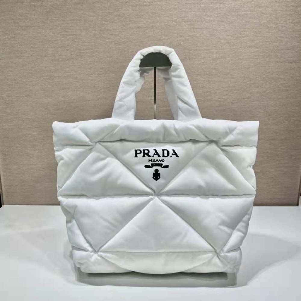 Close-up of silver-tone Prada logo on white padded Re-Nylon tote bag