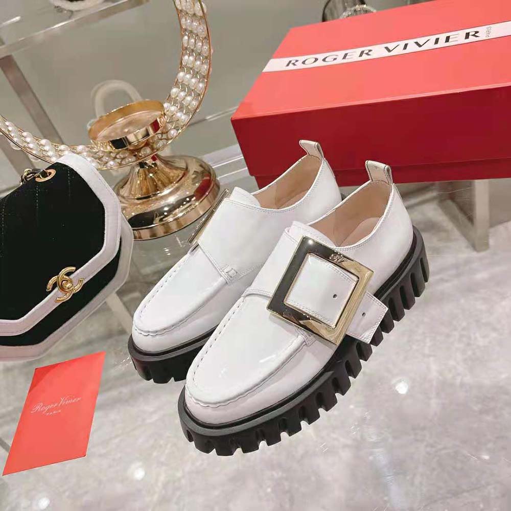 Top-down look at the glossy white patent leather surface of Roger Vivier loafers
