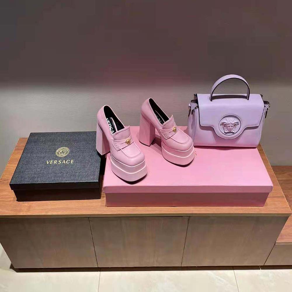 Close-up of Versace gold medallion on pink Intrico platform loafers