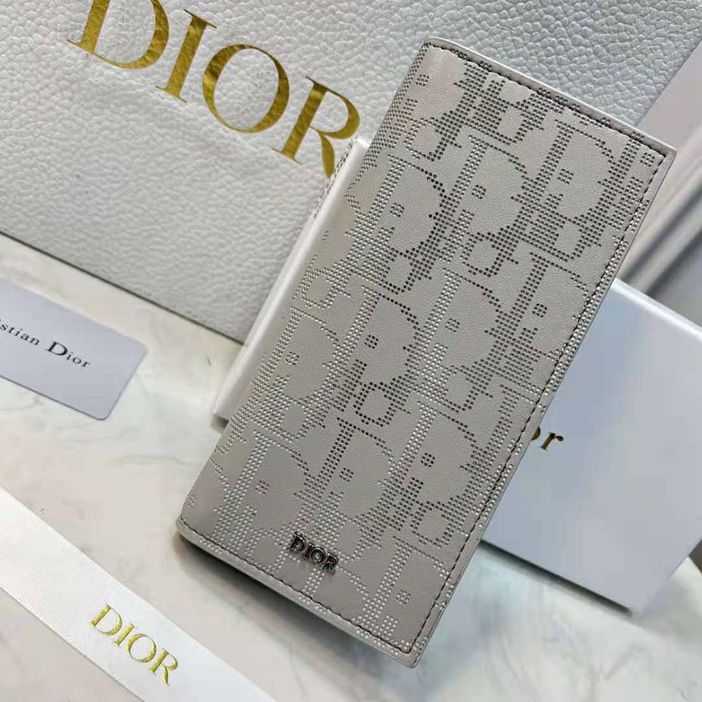 Close-up on embossed Dior Oblique pattern on gray galaxy leather wallet