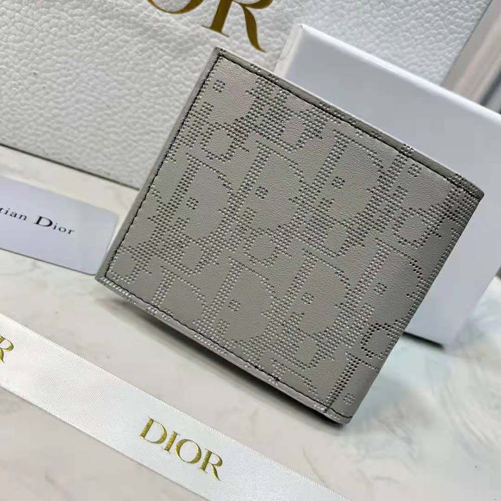 Close-up on silver hardware and embossed Dior signature wallet detail
