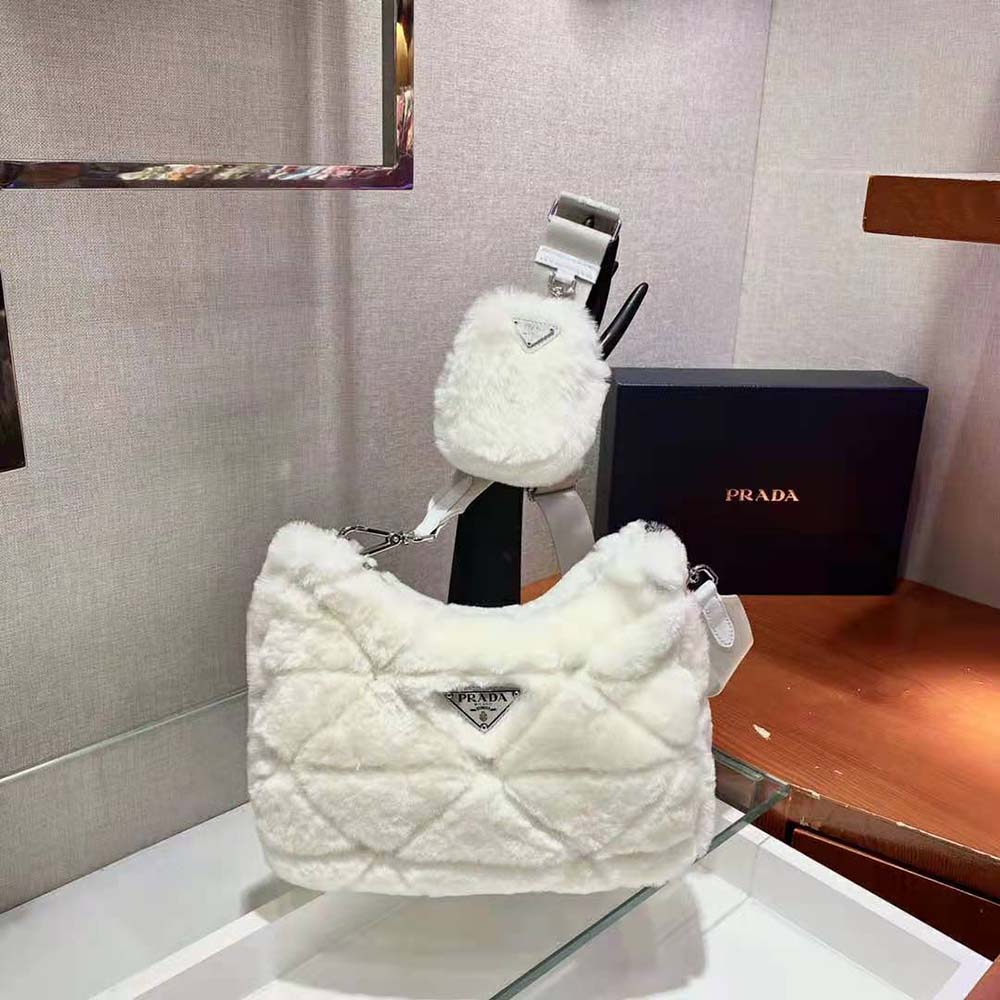 Close-up on Prada triangle motif and silver hardware detail on shearling bag