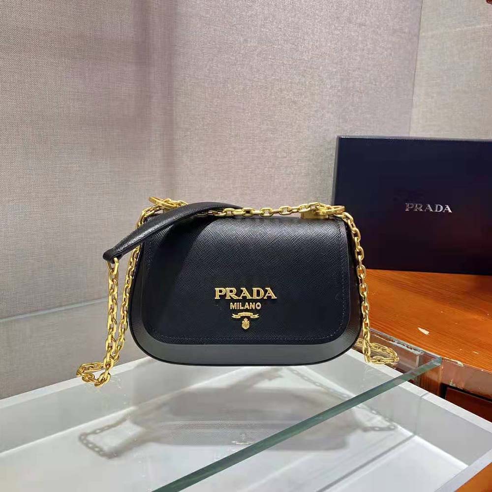 Close-up on gold Prada logo hardware on black saffiano leather bag