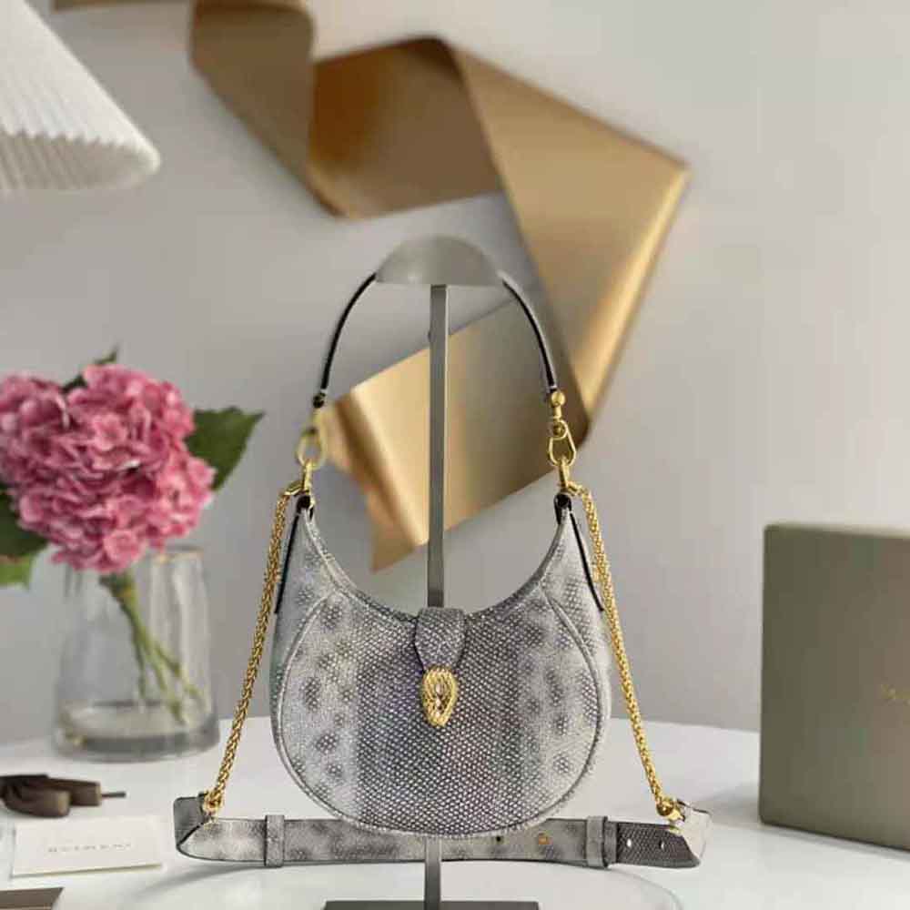 Close-up detail of gold-tone serpent head clasp on Bvlgari Women Serpenti Ellipse Crossbody Bag-Silver