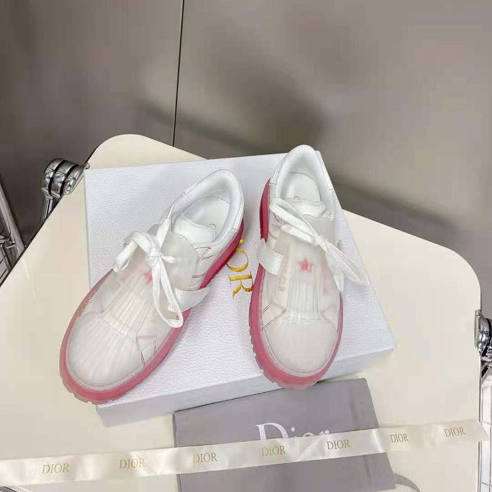 Overhead angle highlighting white calfskin and red rubber details on sneaker