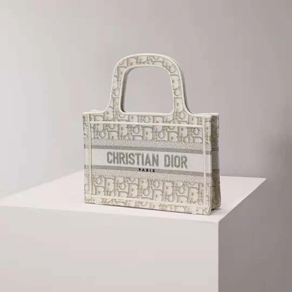 Side angle showing compact silhouette of Dior Women Mini Dior Book Tote beige canvas