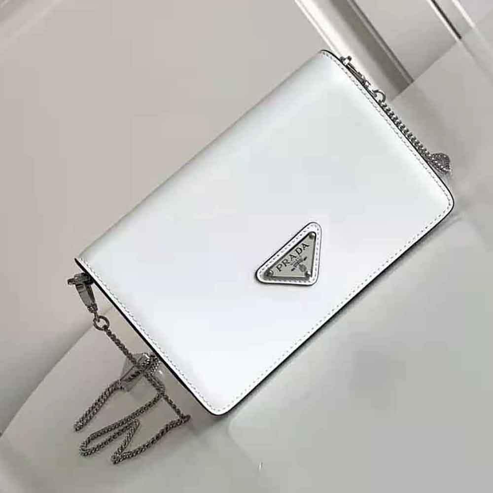 Close-up of silver Prada logo and brushed leather texture on shoulder bag