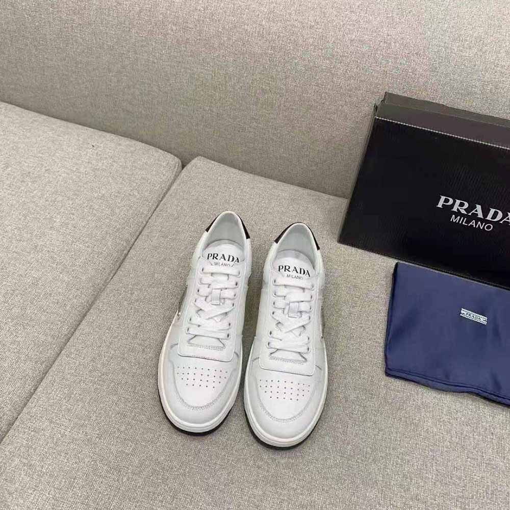 Close-up of lace-up and Prada logo on white leather sneakers