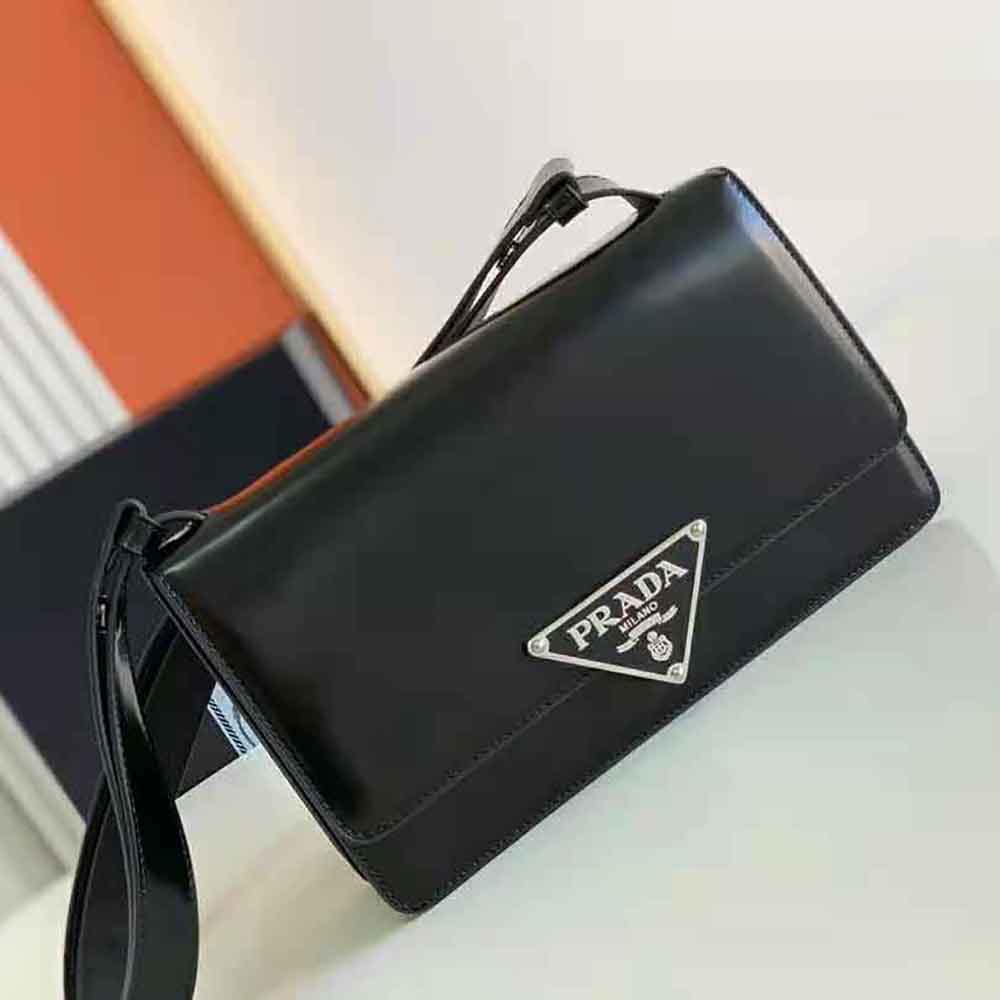 Close-up detail of brushed leather and Embleme clasp on Prada bag