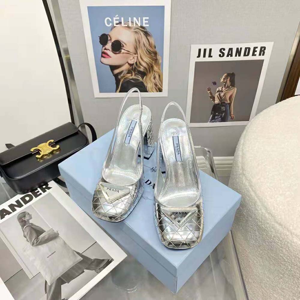 Close-up detail of Prada logo hardware on silver slingback pumps