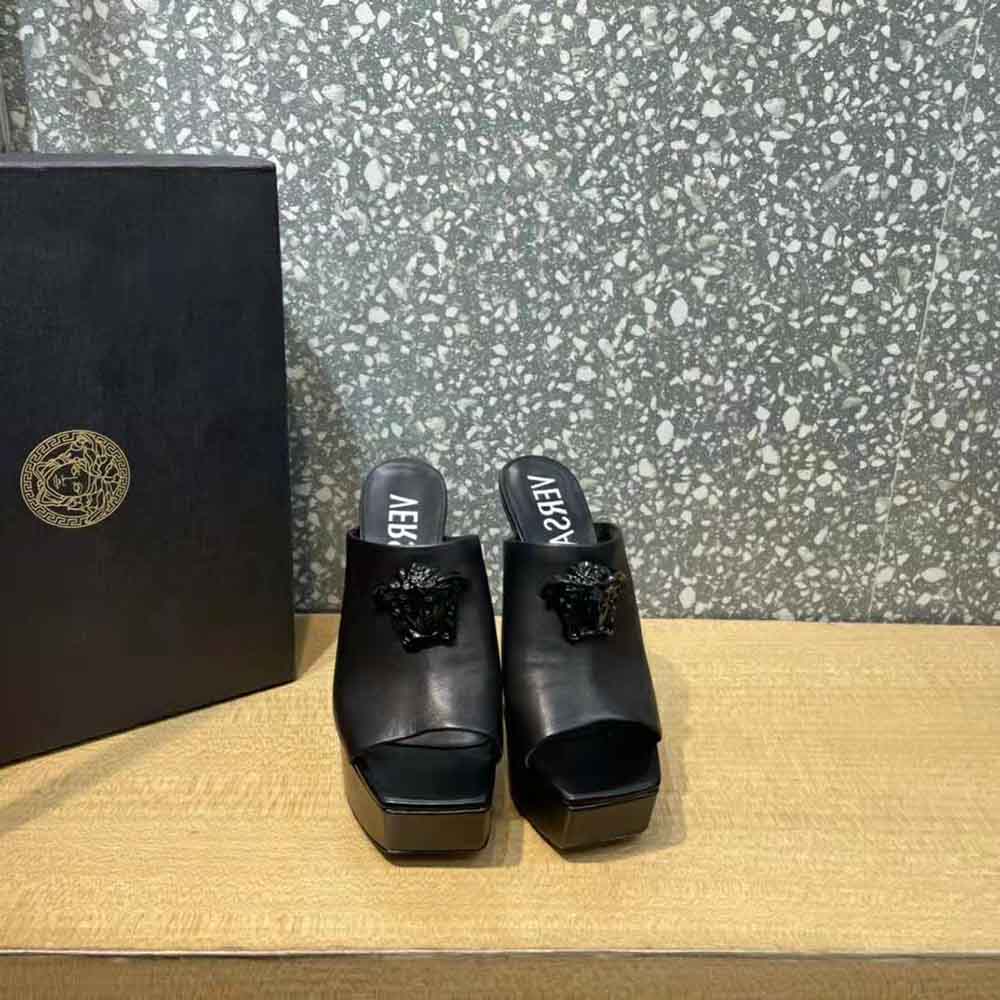 Close-up of gold Medusa logo hardware on Versace platform mules