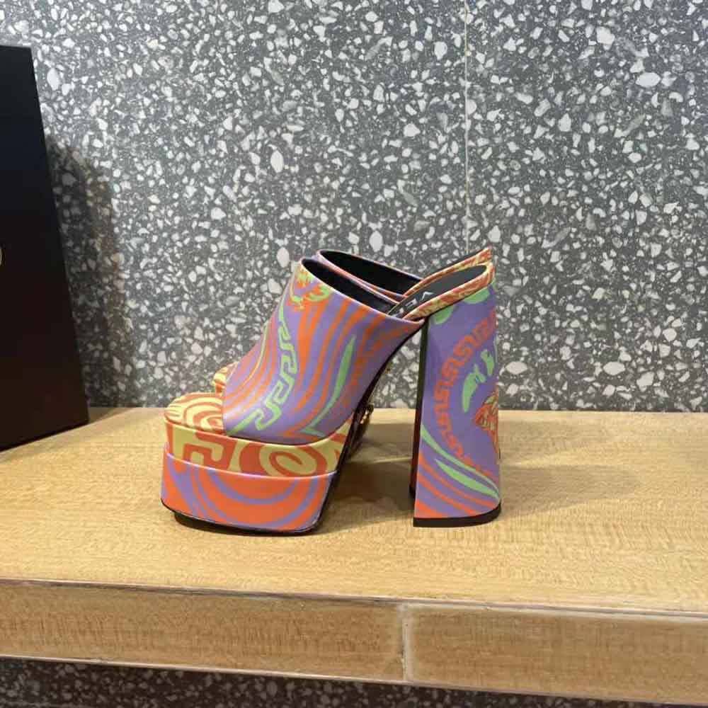 Close-up of gold Medusa hardware on purple Versace Women Medusa Music Platform Mules