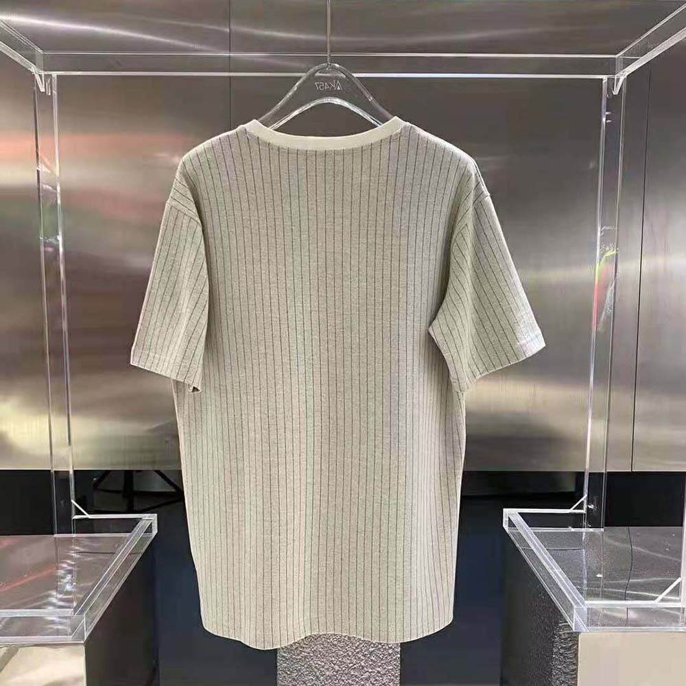 Side angle showcasing relaxed fit and Dior Atelier logo on silver T-shirt