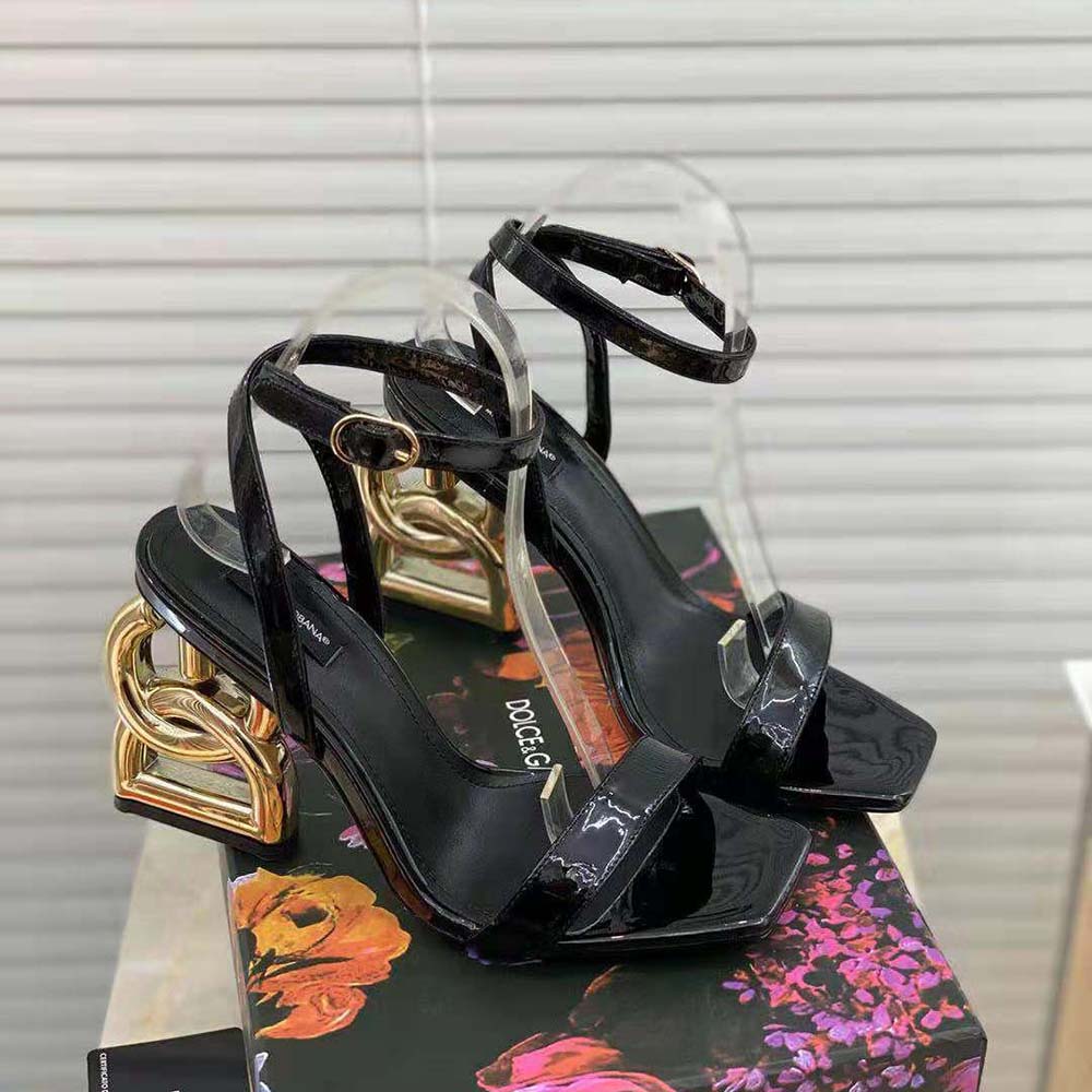 Close-up on black patent leather and D&G embossed buckle detail