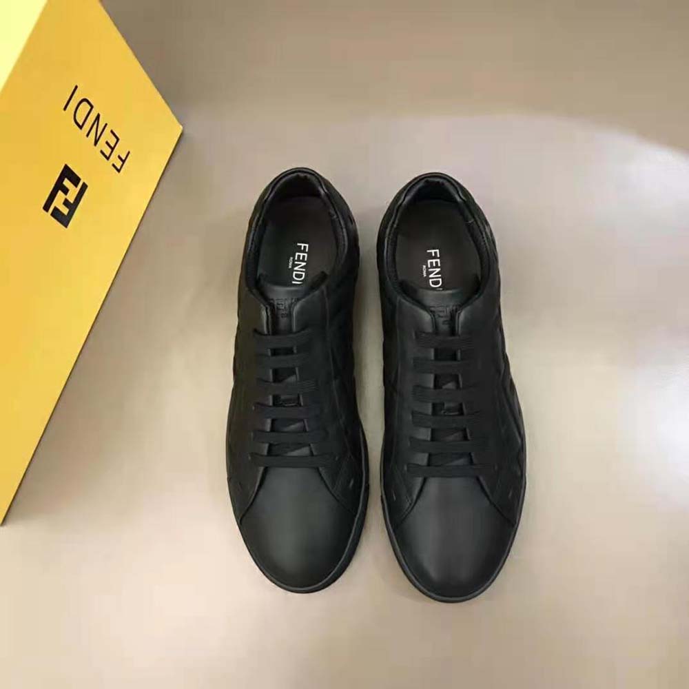 Close-up on embossed 3D Macro FF motif on black leather sneaker