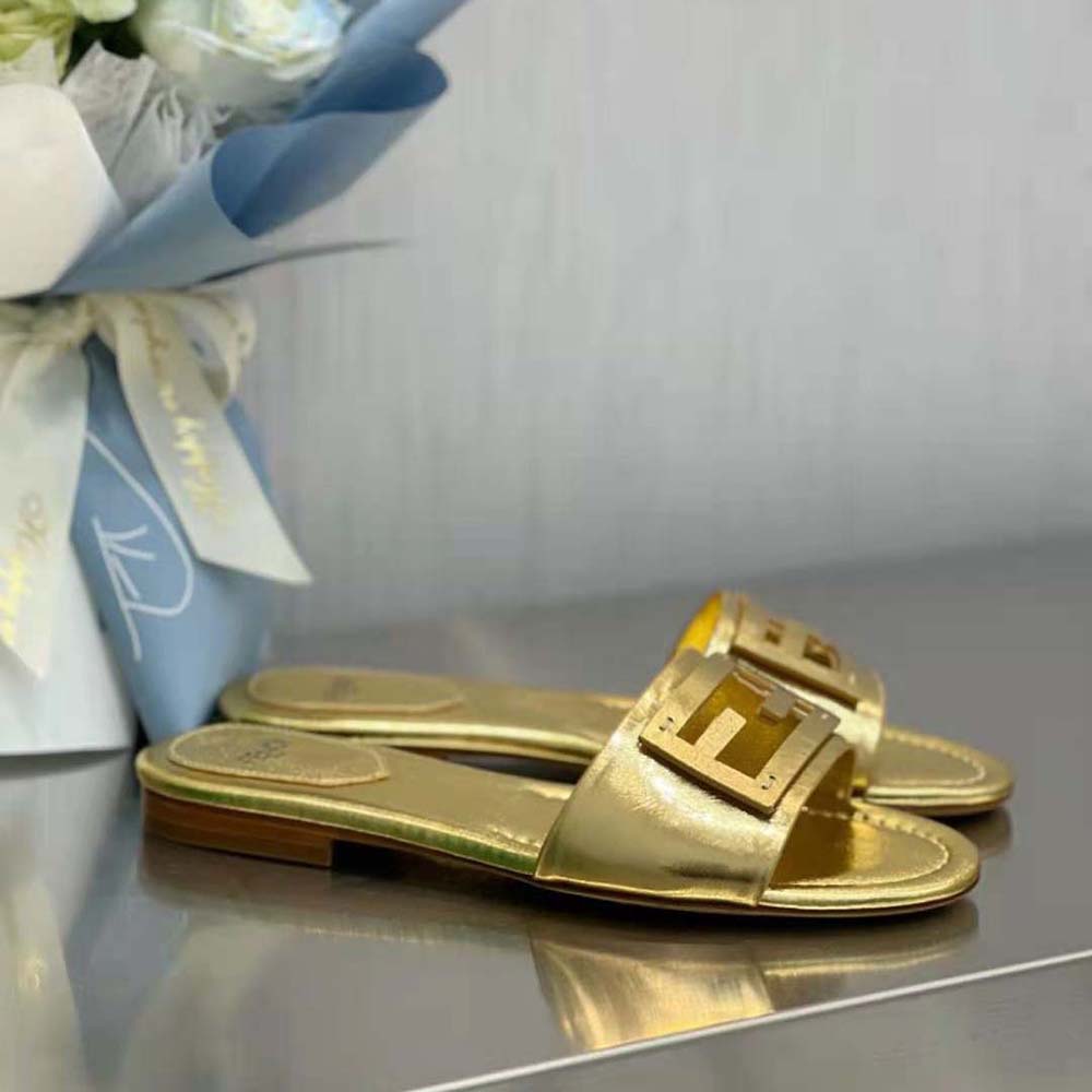 Close-up detail of gold nappa leather and signature Fendi hardware on slides