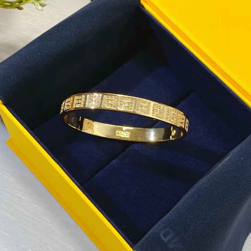 Angled view showing the narrow band and gold finish of Fendi Women Stiff Narrow-Band FF Bracelet Gold-colored