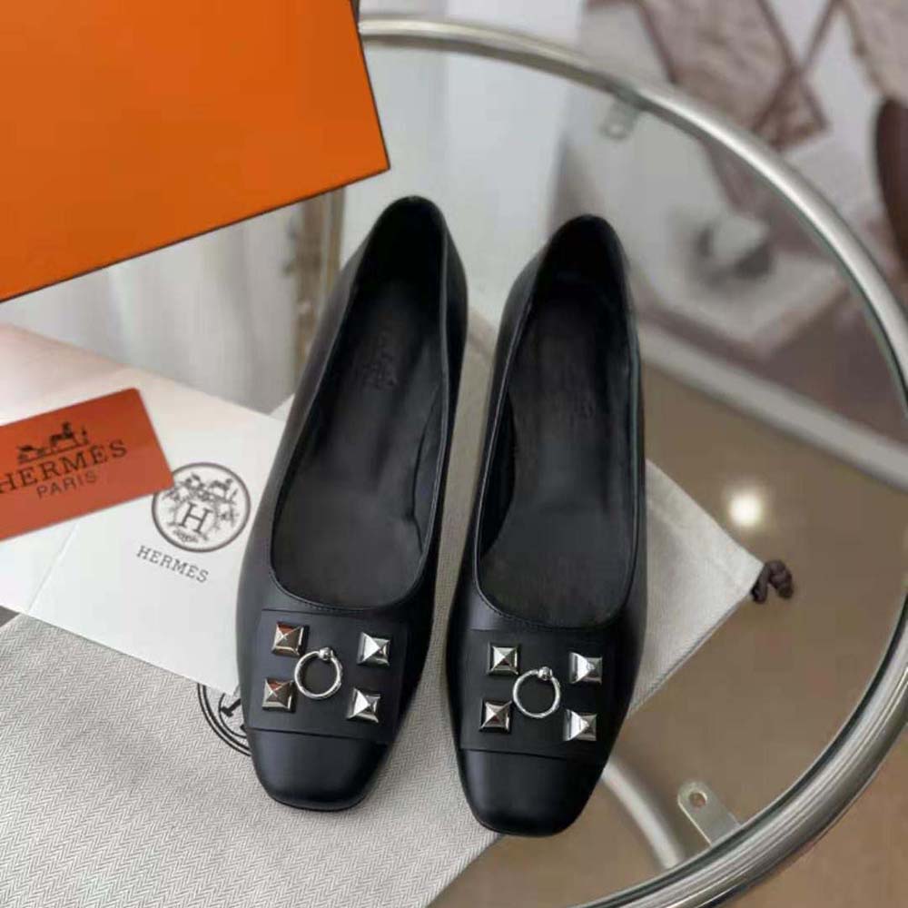 Close-up detail of signature Hermes embossed hardware on ballet flat