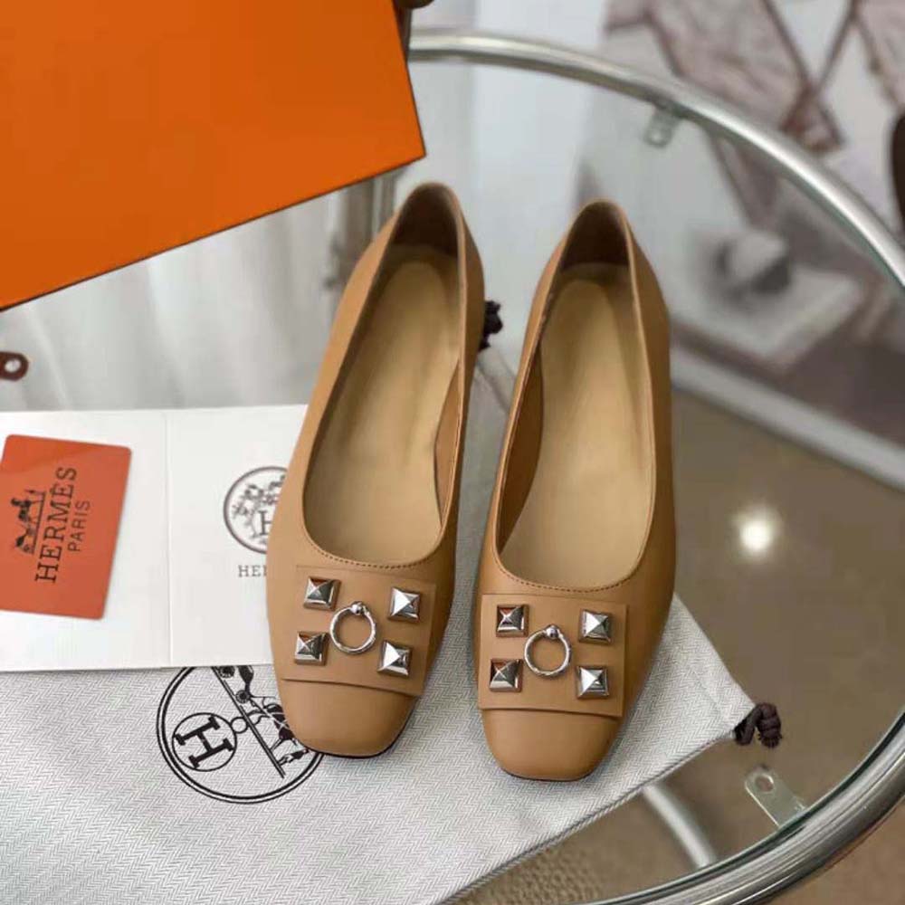 Close-up detail of brown calfskin and Hermes logo on ballet flat