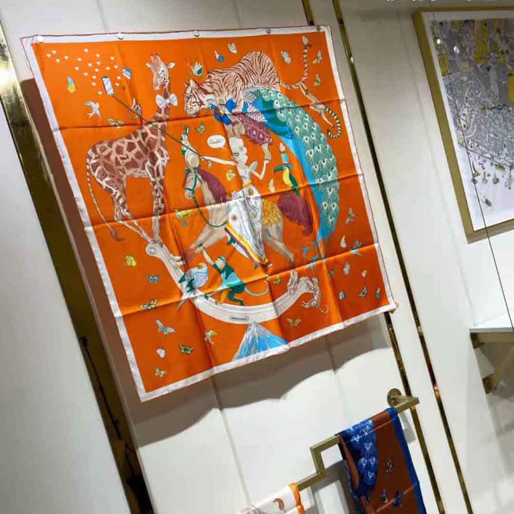 Flat lay showing full Hermes Women Hermes Story Scarf 90 orange silk square