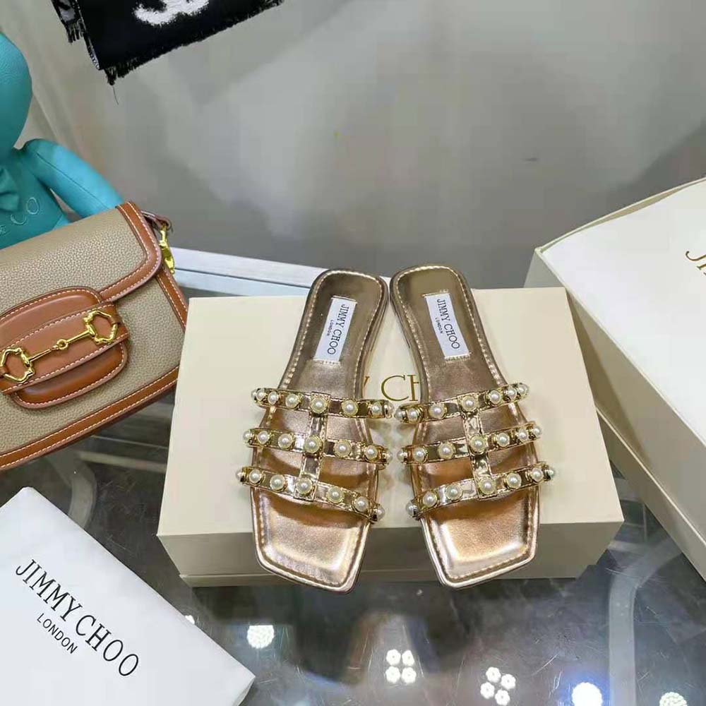 Close-up of pearl stud detail on Jimmy Choo Hazal Flat Gold Flats