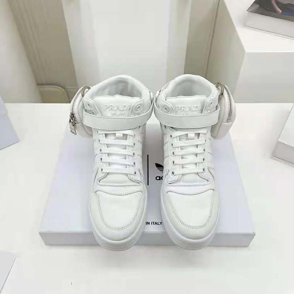 Close-up on signature Prada logo hardware of white sneakers