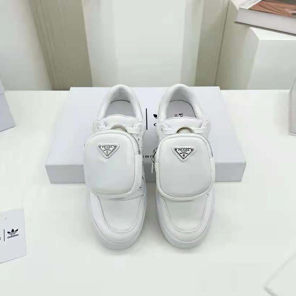 Close-up on lace and Prada x Adidas logo detail, white sneakers