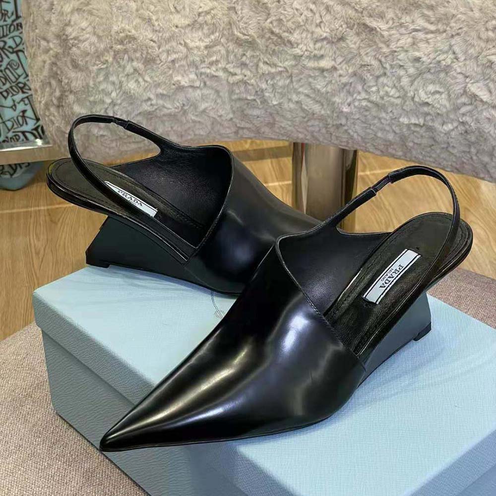 View of 65mm heel and signature Prada embossing on black pumps
