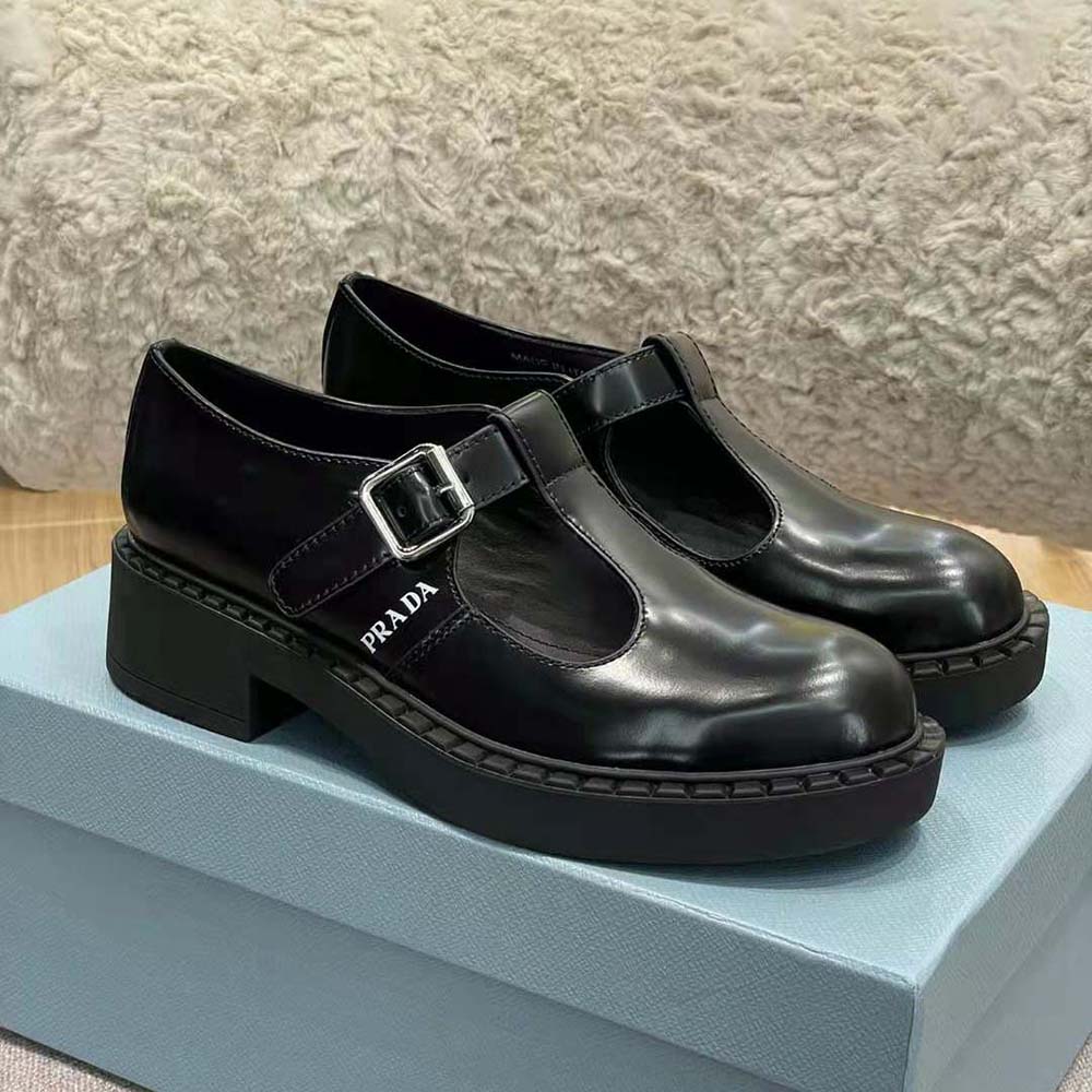 Close-up of brushed leather texture and silver buckle on Prada T-Strap shoes