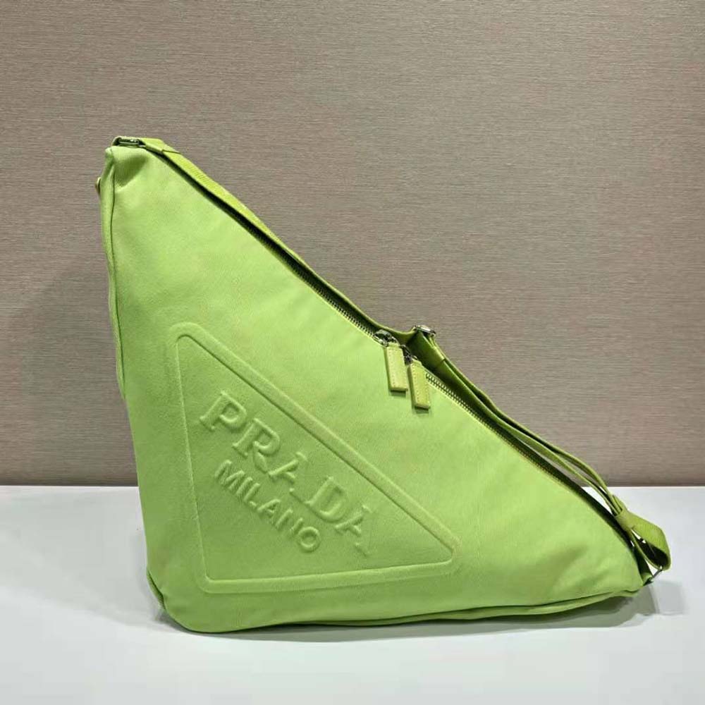 Close-up of green canvas texture and triangle metal logo on Prada bag