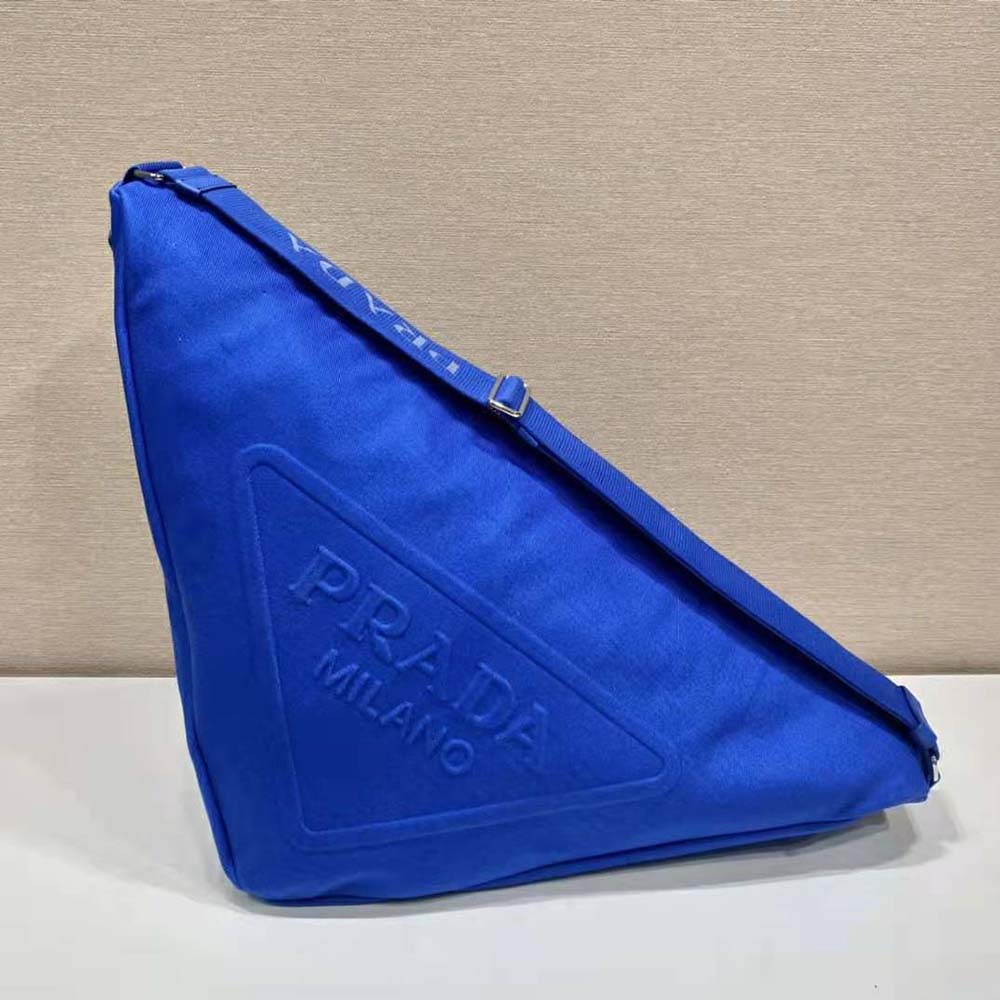 Close-up of silver Prada triangle logo on Navy canvas bag